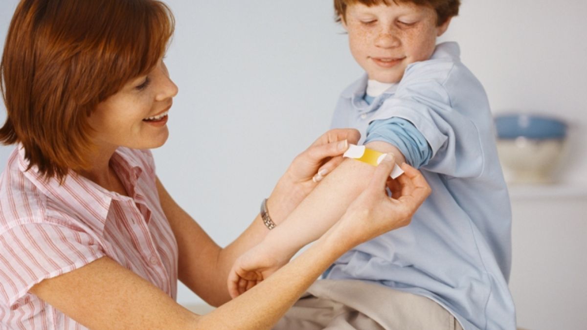 Mother Placing Bandage On Son