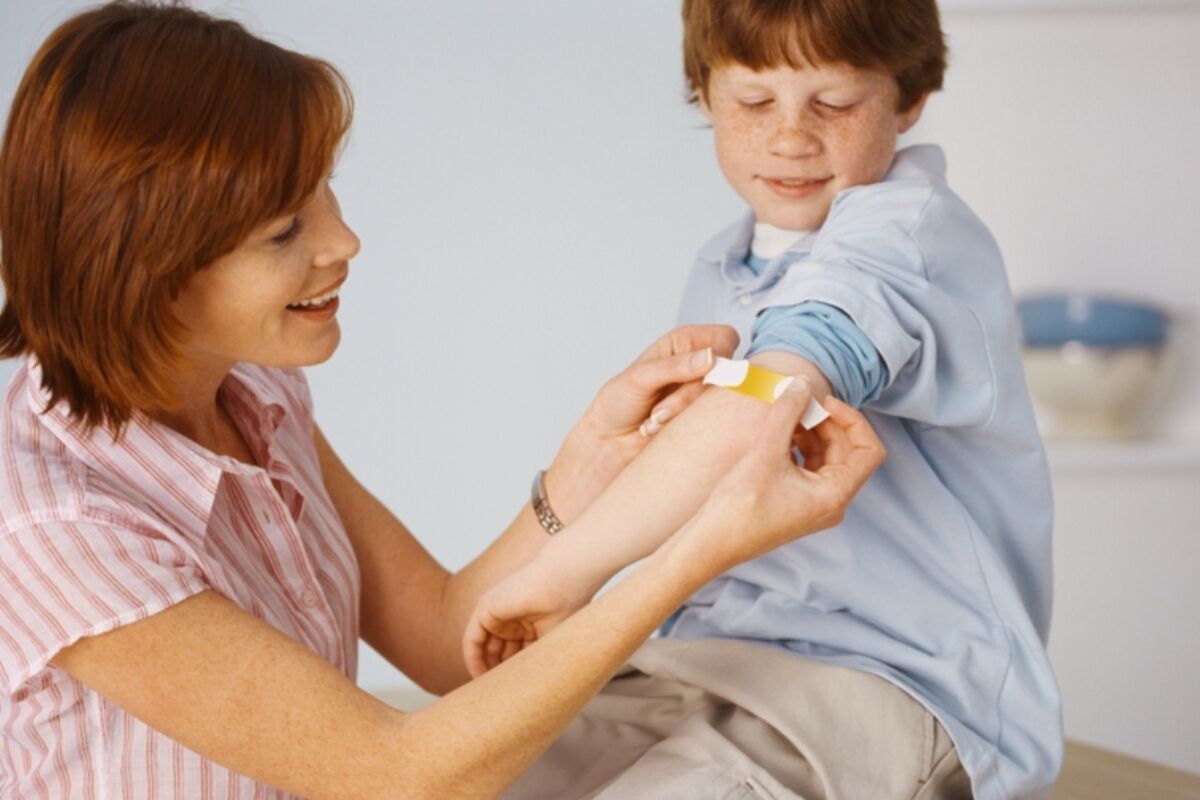 Mother Placing Bandage On Son