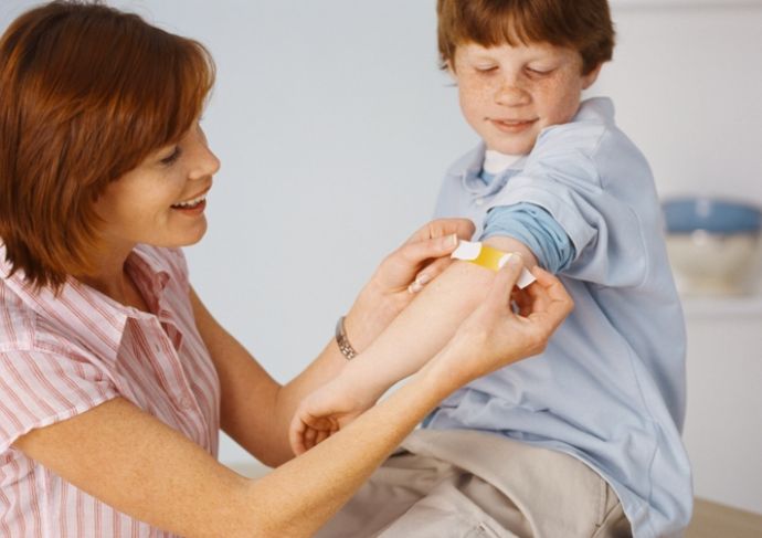 Mother Placing Bandage On Son