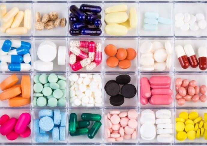 a variety of different colored pills organized in a box with compartments