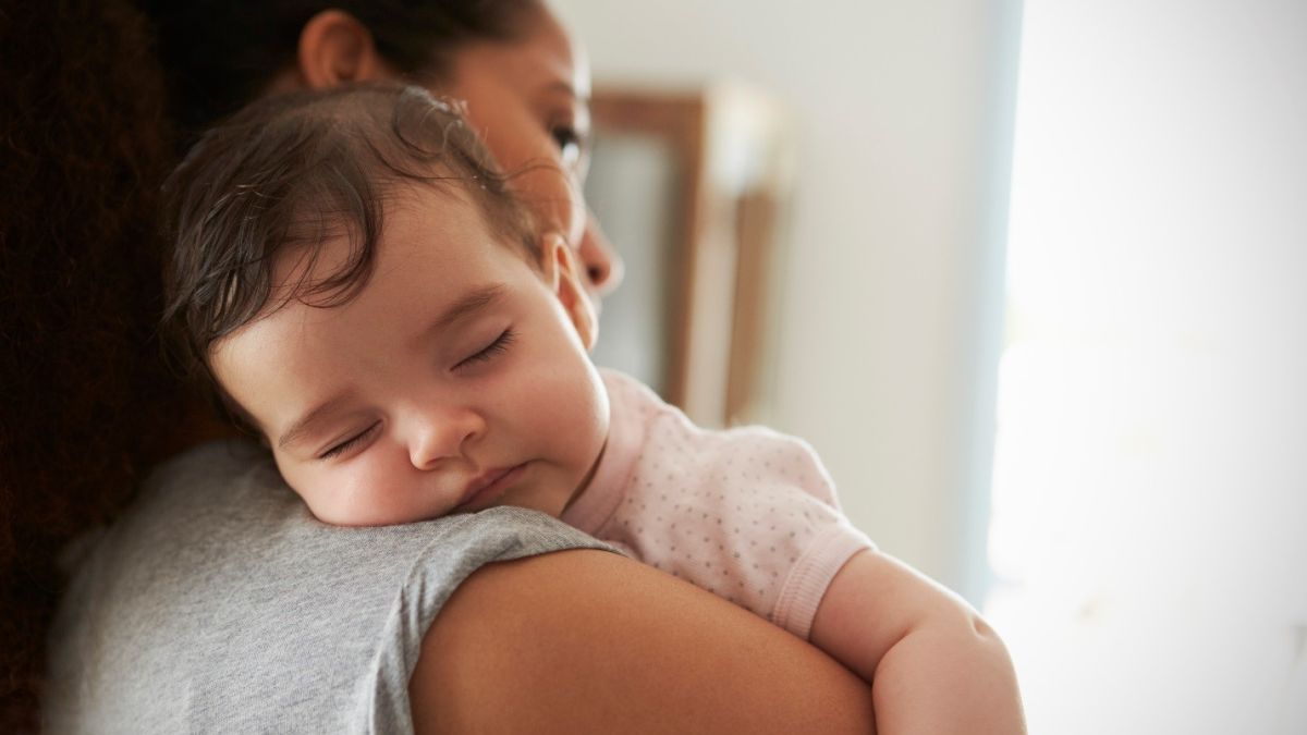 mother holding baby after feeding