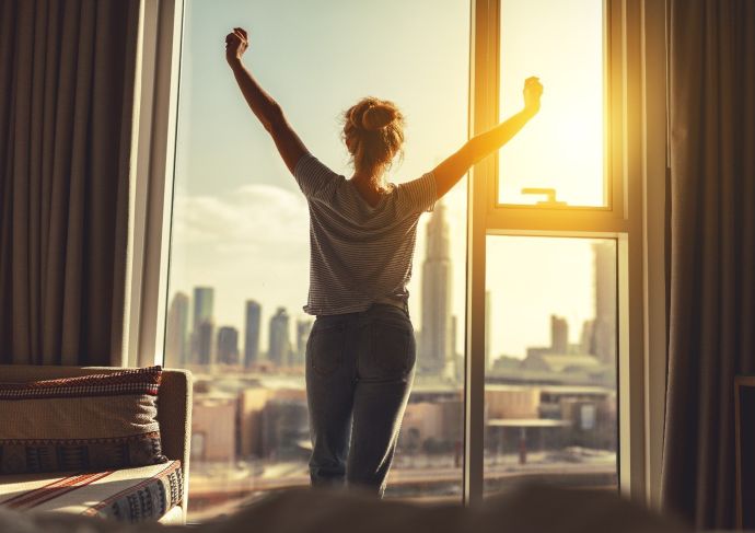 Thinkstockphotos 912257262 Woman Stretching Morning Window