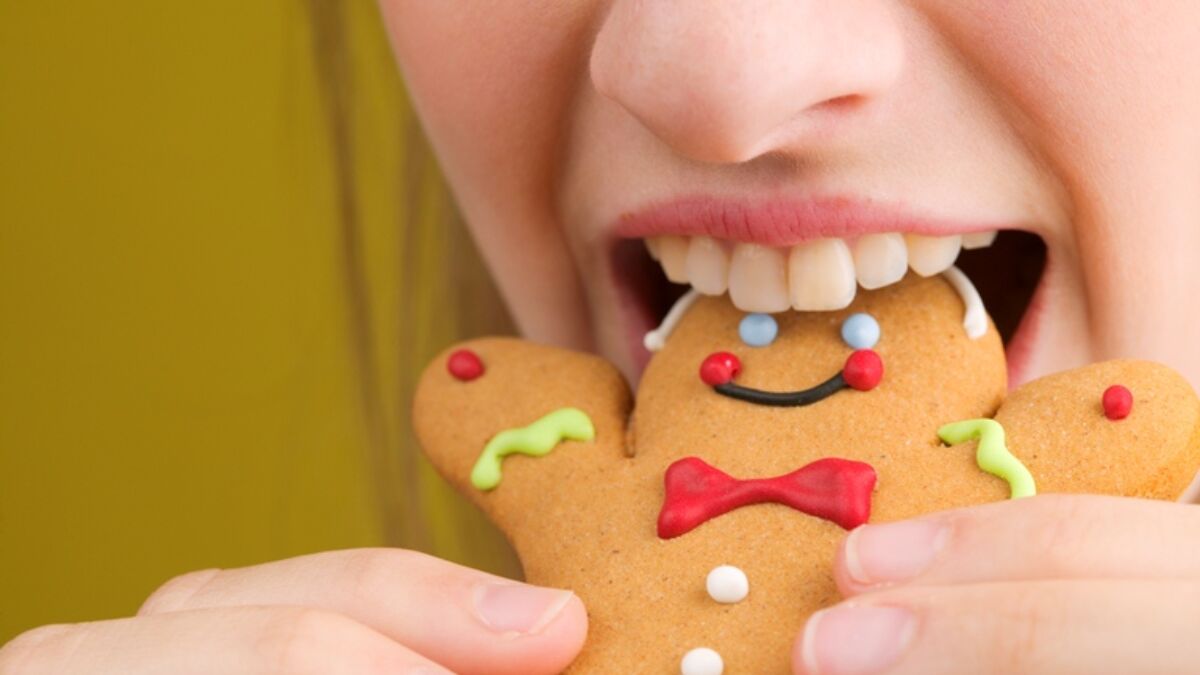 woman eating a gingerbread man cookie