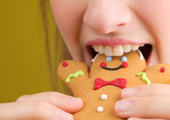 woman eating a gingerbread man cookie