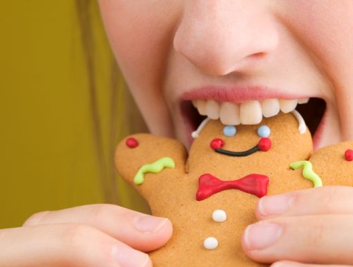 woman eating a gingerbread man cookie