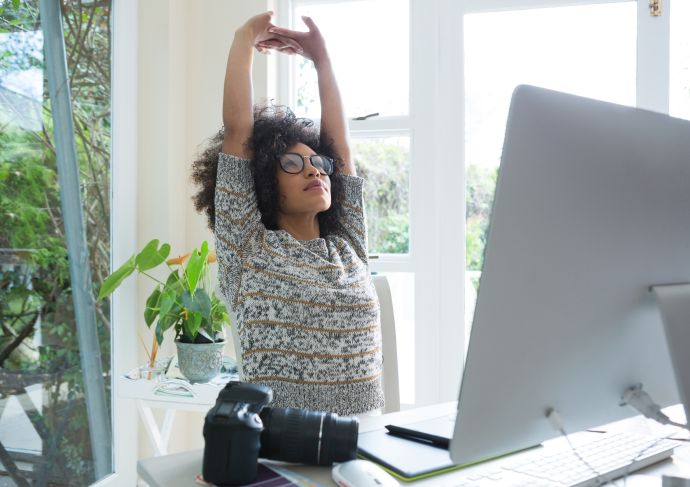 young woman stretching at desk