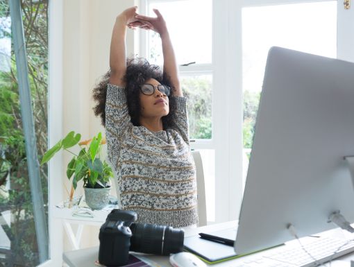 young woman stretching at desk