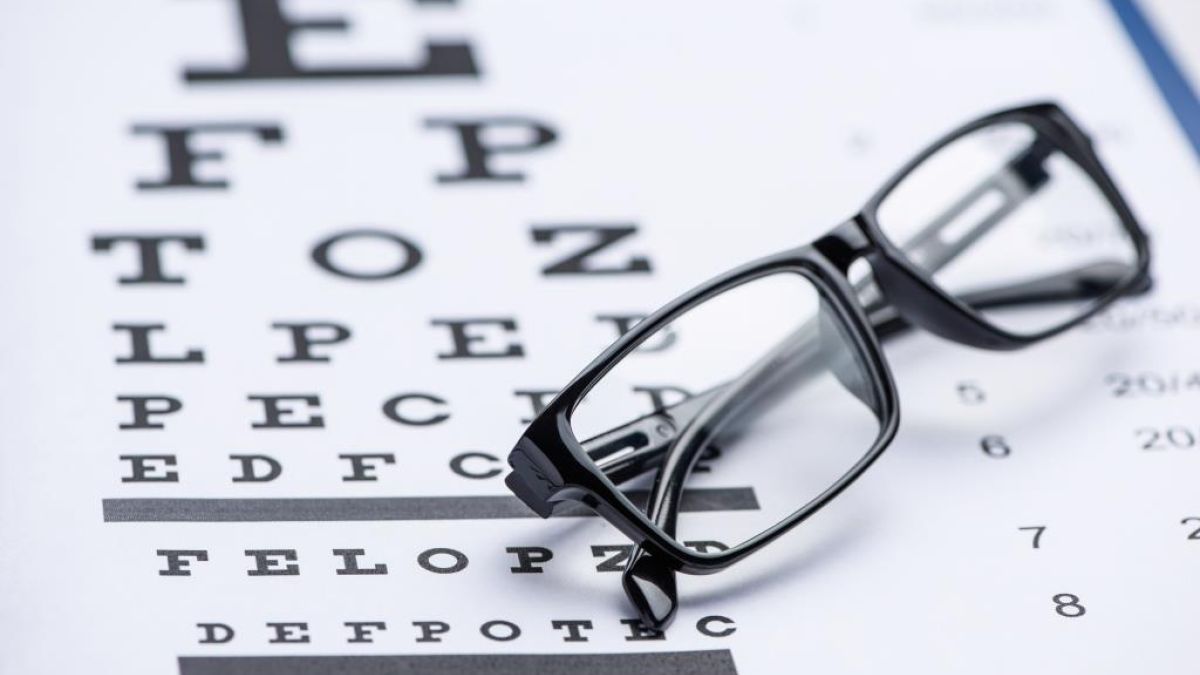 Pair of glasses resting on an eye chart