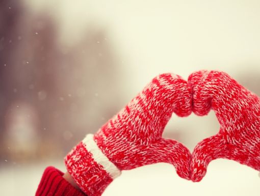 Pair of red mittens forming a heart.
