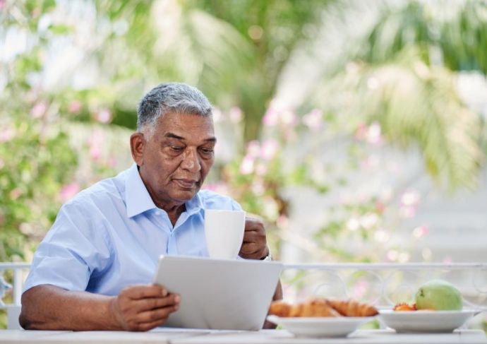 man reading outside while enjoying a meal