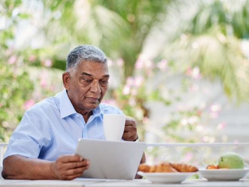 man reading outside while enjoying a meal