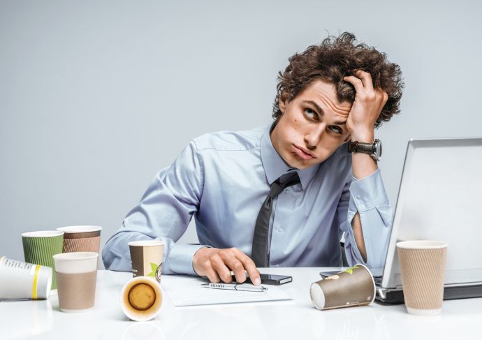 man who looks worried sitting at computer
