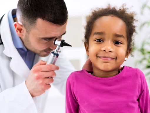 Doctor examining child's ear