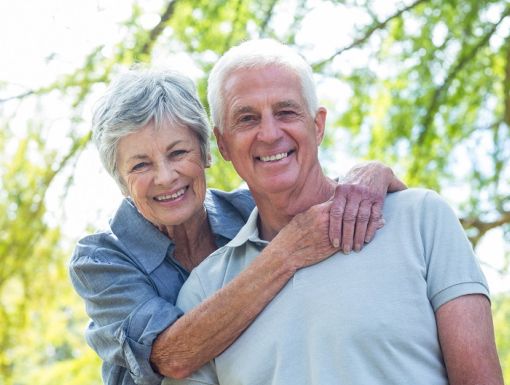 Happy older couple hugging outside