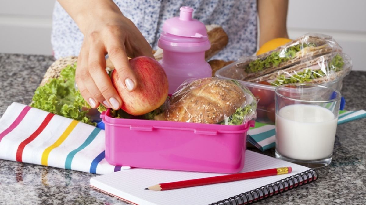 woman packing healthy lunch in a lunchbox