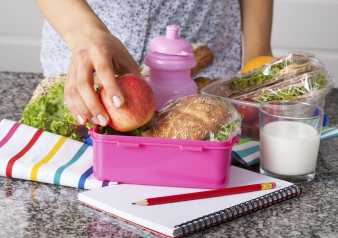 woman packing healthy lunch in a lunchbox
