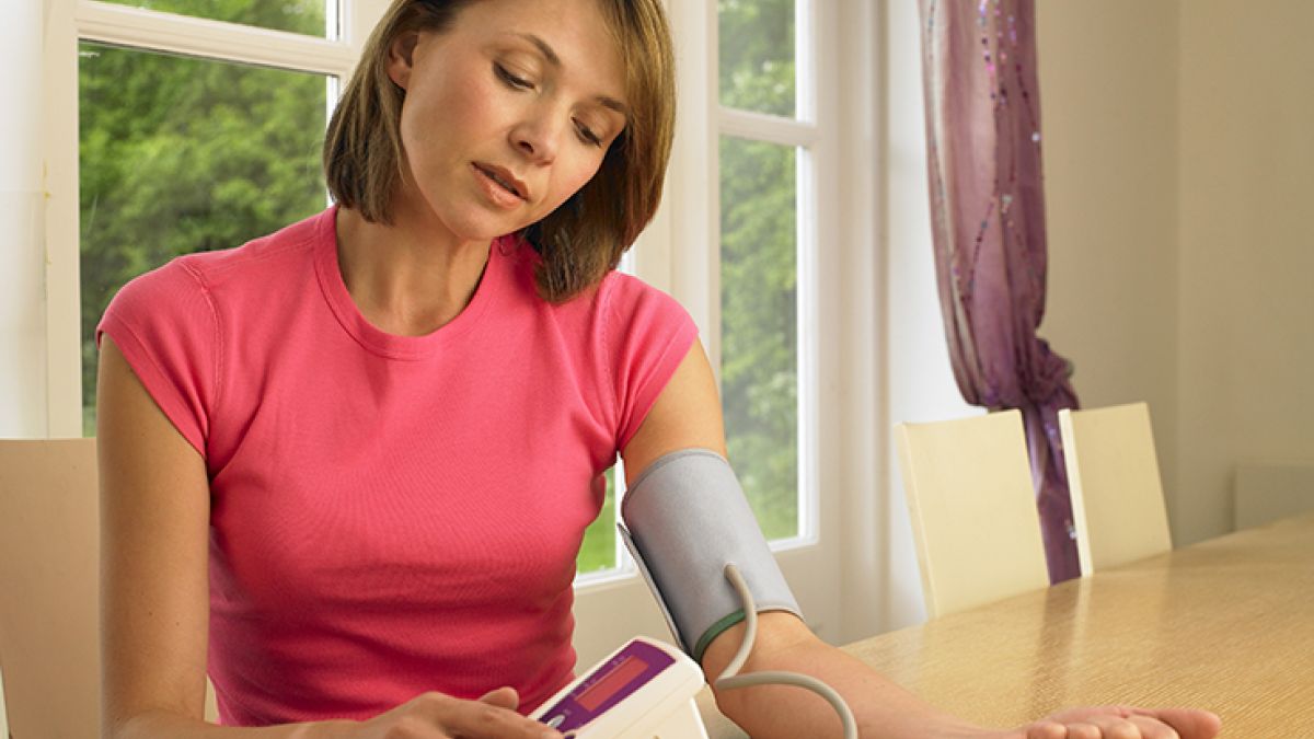 woman checking her blood pressure at home