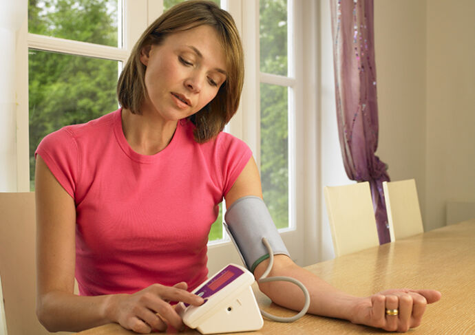 woman checking her blood pressure at home