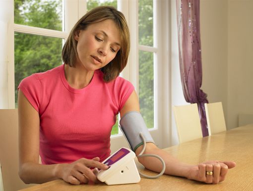 woman checking her blood pressure at home
