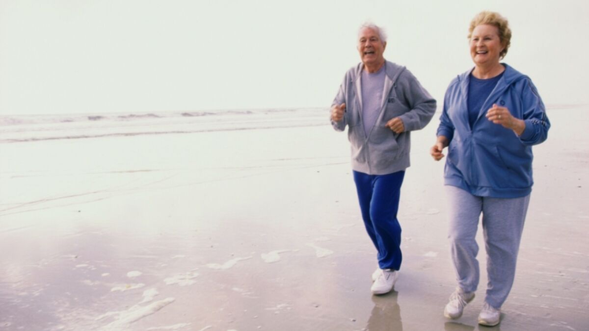 122413055 Senior Couple Jogging On Beach