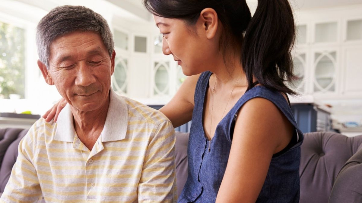 Young-woman-sitting-on-sofa-with-older-man