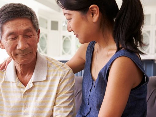 Young-woman-sitting-on-sofa-with-older-man