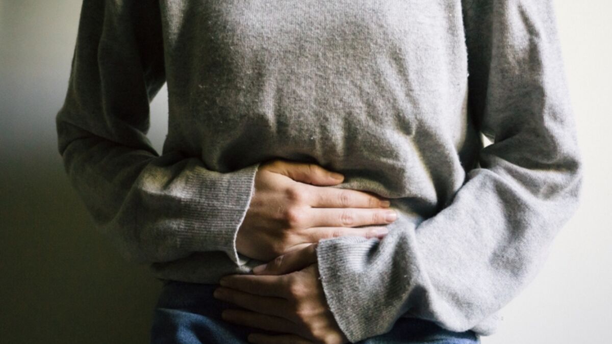 woman holding her stomach after stomach flu