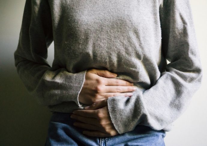 woman holding her stomach after stomach flu