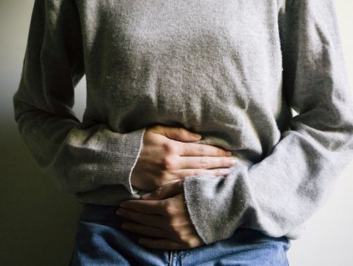 woman holding her stomach after stomach flu