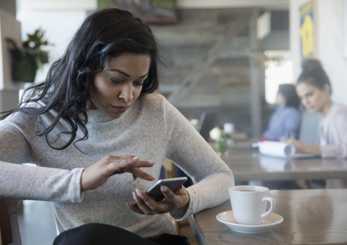 Woman using cell phone wondering about panic attacks