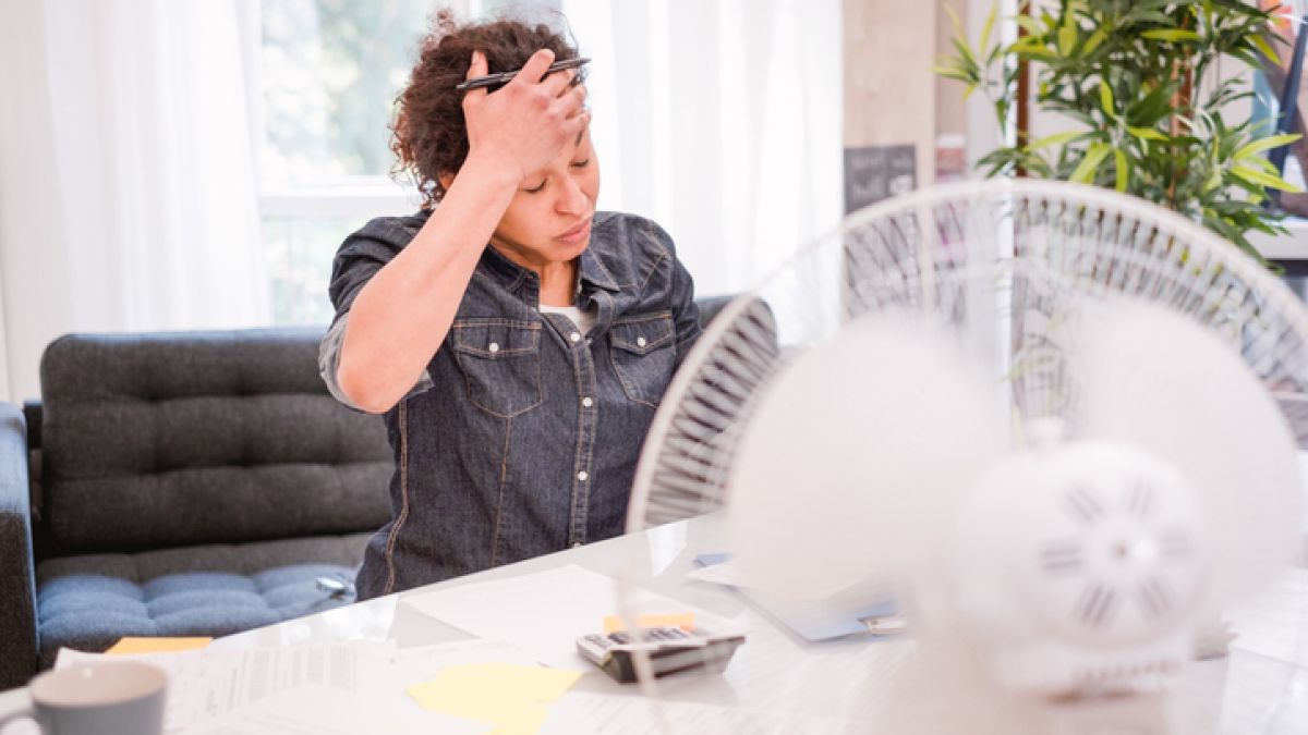 woman with VMS (hot flashes) sitting in front of a fan