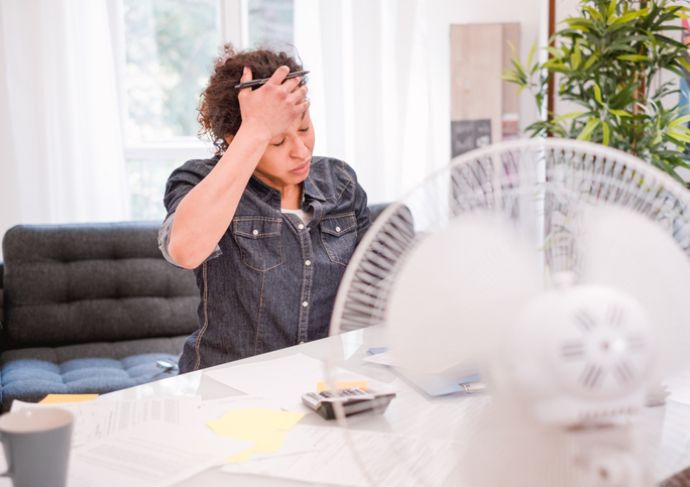 woman with VMS (hot flashes) sitting in front of a fan