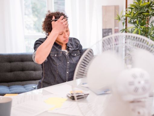 woman with VMS (hot flashes) sitting in front of a fan