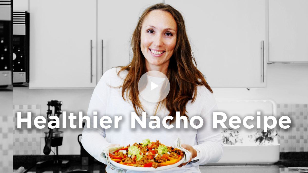 Health coach holding dish of healthier nachos.