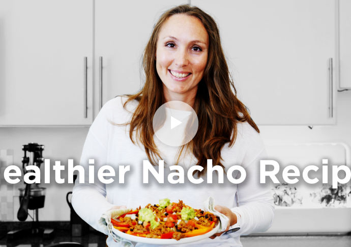 Health coach holding dish of healthier nachos.