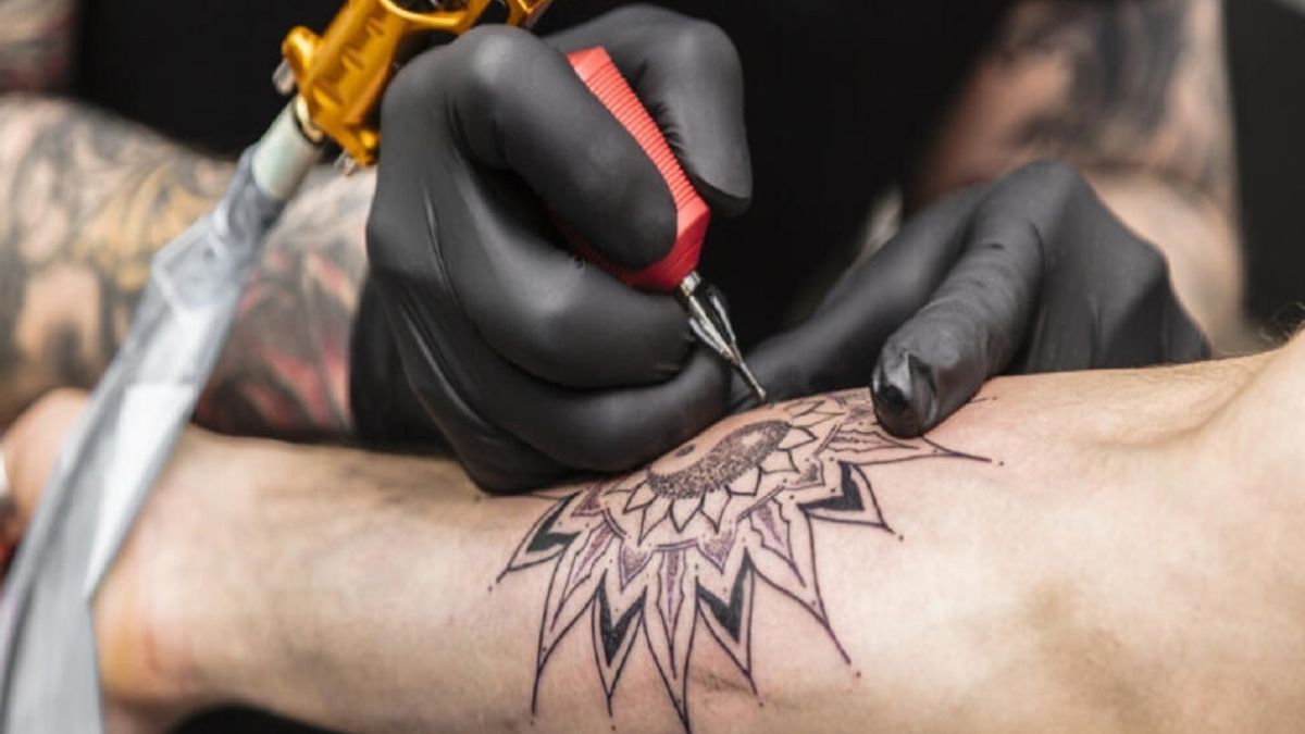 Process of creating tattoo in form of black flower