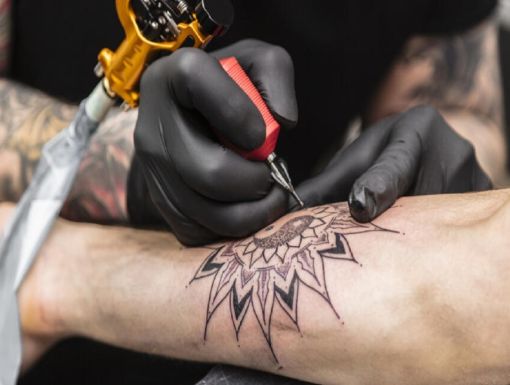Process of creating tattoo in form of black flower