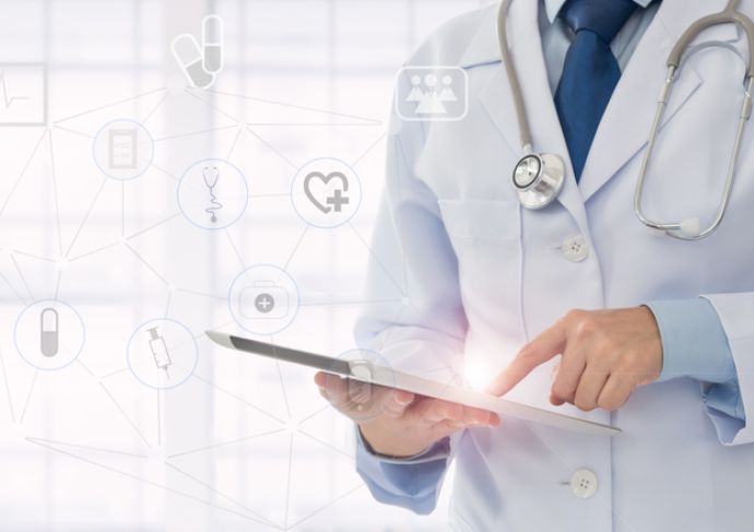doctor-holding-clipboard-in-front-of-wall-with-digital-images