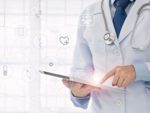 doctor-holding-clipboard-in-front-of-wall-with-digital-images