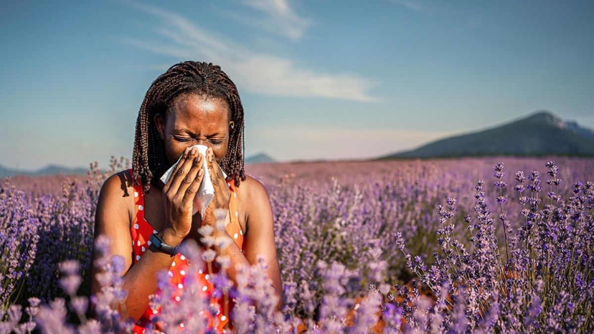 Woman in flower field sneezing