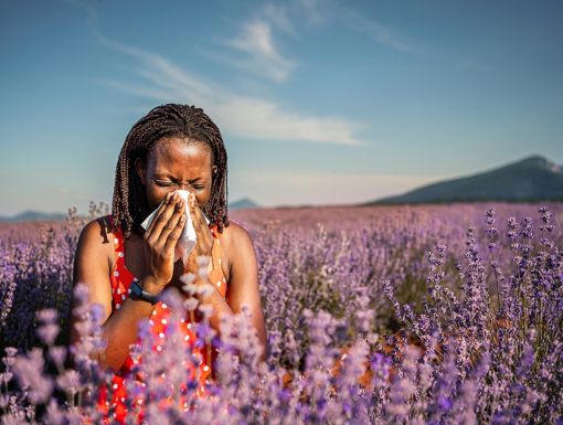 Woman in flower field sneezing