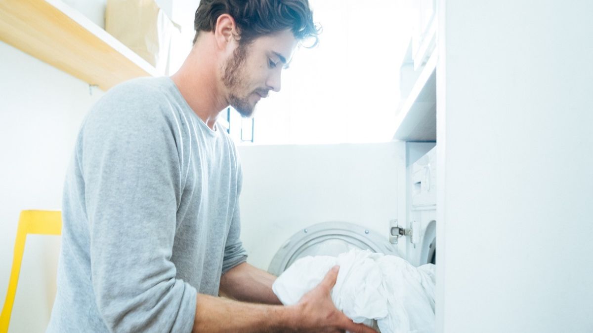 Man at home washing sheets