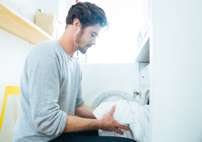 Man at home washing sheets
