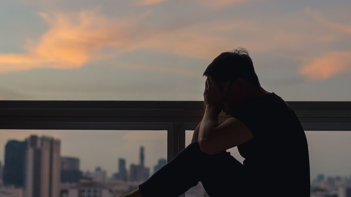 A man sitting and feeling depressed on bed