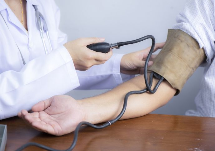 Doctor using checking patients blood pressure