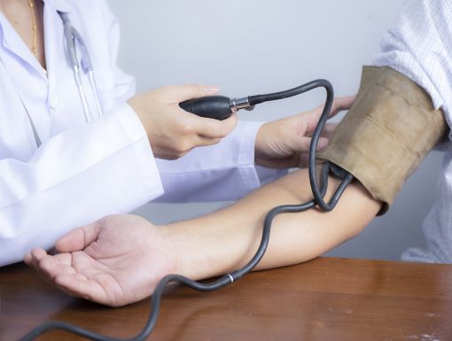 Doctor using checking patients blood pressure