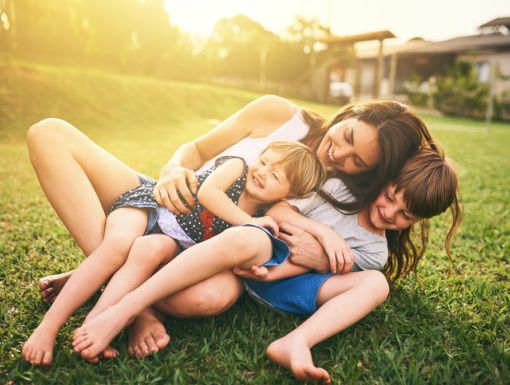 mother playing with children outside