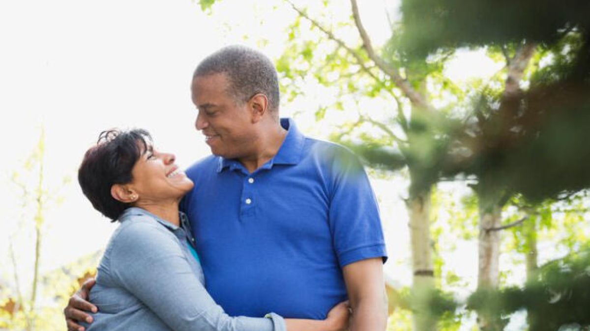 Older couple hugging each other outside