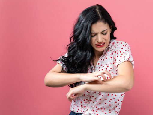 Woman Itching Arm Getty Images 1044939258