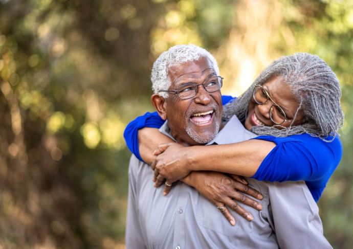 Mature couple piggyback in park